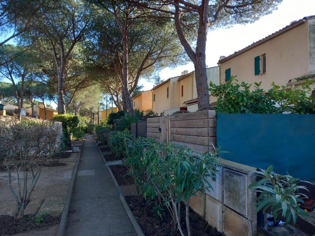 un trottoir devant une maison arborée dans l'établissement Le CENTAURE Proche Centre Naturiste, au Cap d'Agde