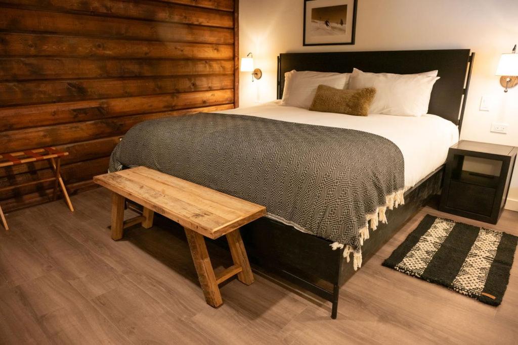 a bedroom with a large bed and a wooden wall at High Creek Lodge and Cabins in Pagosa Springs