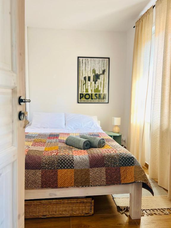 a bedroom with a bed with a quilt on it at Apartament Rosalia in Srebrna Góra