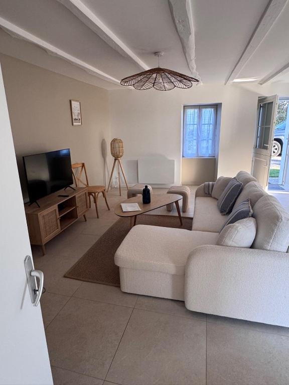 un salon avec un canapé blanc et une télévision dans l'établissement Maison familiale neuve, plage à 3min, jardin, à Assérac