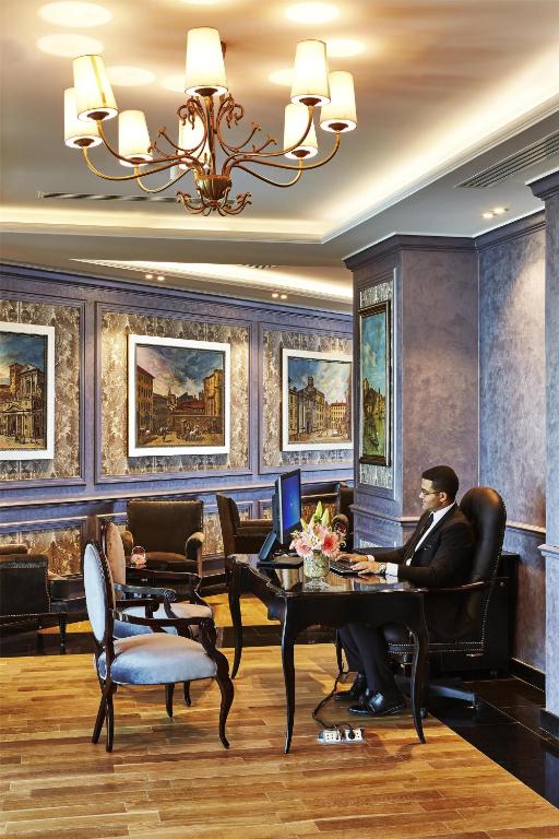 a man sitting at a table with a computer at Royal Maxim Palace Kempinski Cairo in Cairo