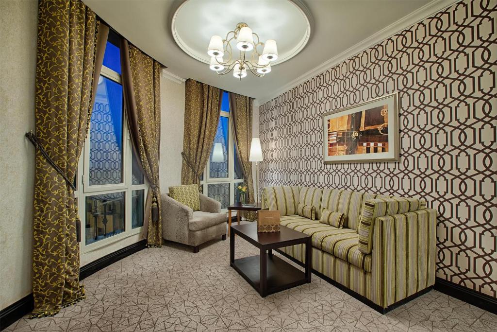 a living room with a couch and chairs and windows at Royal Maxim Palace Kempinski Cairo in Cairo