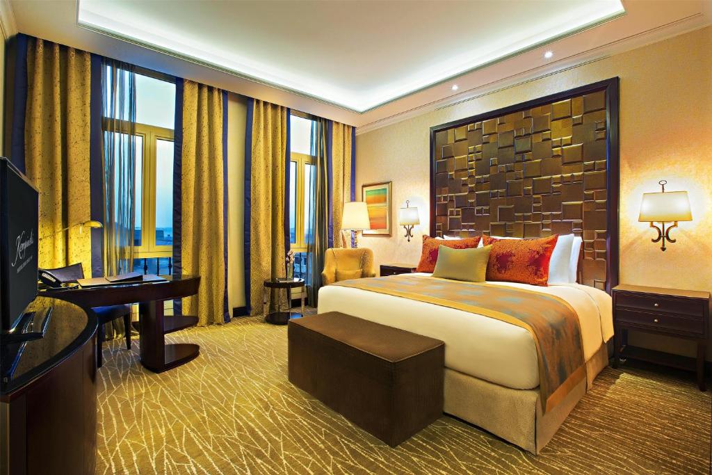a hotel room with a bed and a desk and a television at Royal Maxim Palace Kempinski Cairo in Cairo