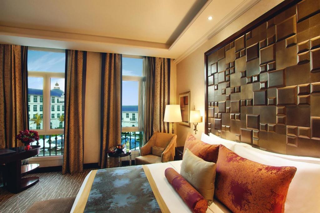 a hotel room with a bed and a large window at Royal Maxim Palace Kempinski Cairo in Cairo