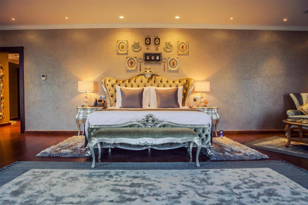 a bedroom with a large bed with a gold headboard at Royal Maxim Palace Kempinski Cairo in Cairo