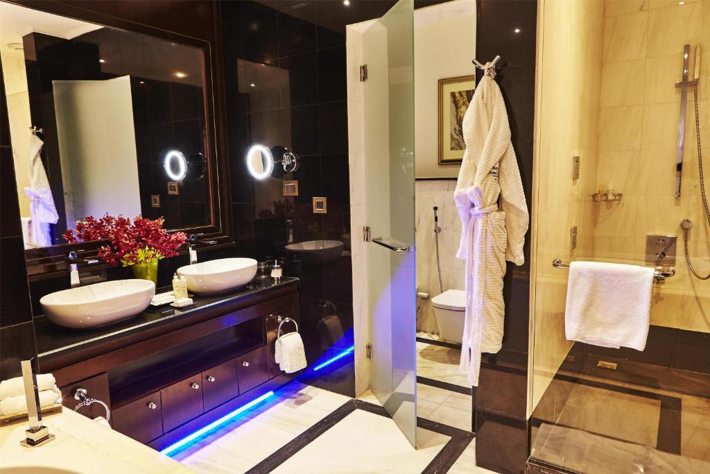 a large bathroom with two sinks and a shower at Royal Maxim Palace Kempinski Cairo in Cairo
