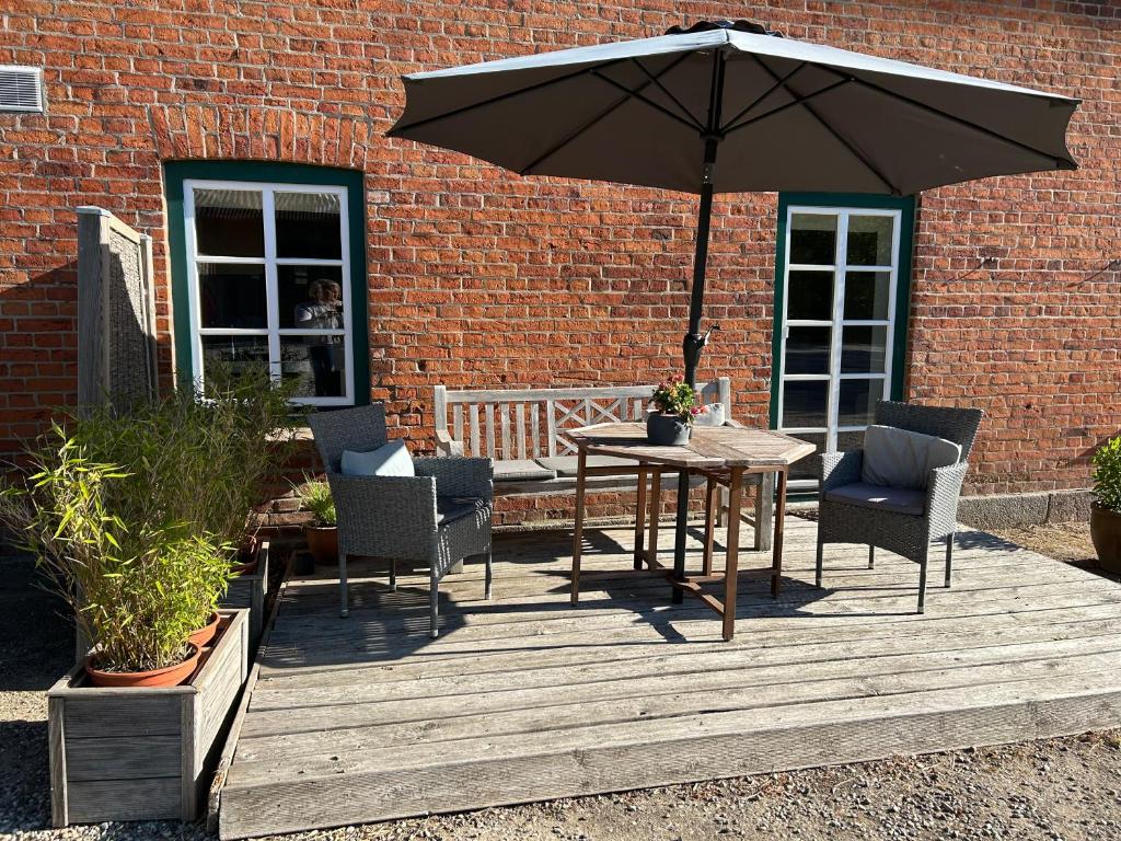 a wooden deck with a table and chairs and an umbrella at Ferienwohnung 1 Hof Flüh in Klenzau