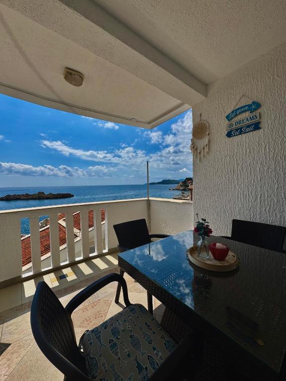 Un comedor con mesa y vista al mar. en Pine&Sea Beach Retreat, en Sveti Stefan