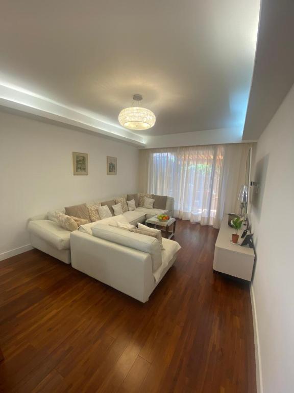 - un salon avec un canapé blanc et du parquet dans l'établissement T4 - proche Monaco a 250m de la plage - 3 lits doubles -6 personnes, à Roquebrune-Cap-Martin