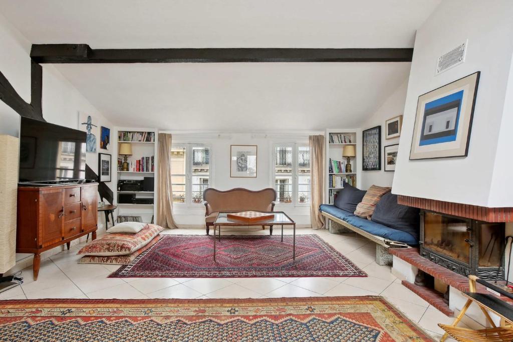 un salon avec un canapé bleu et une cheminée dans l'établissement Le Majestueux, à Paris