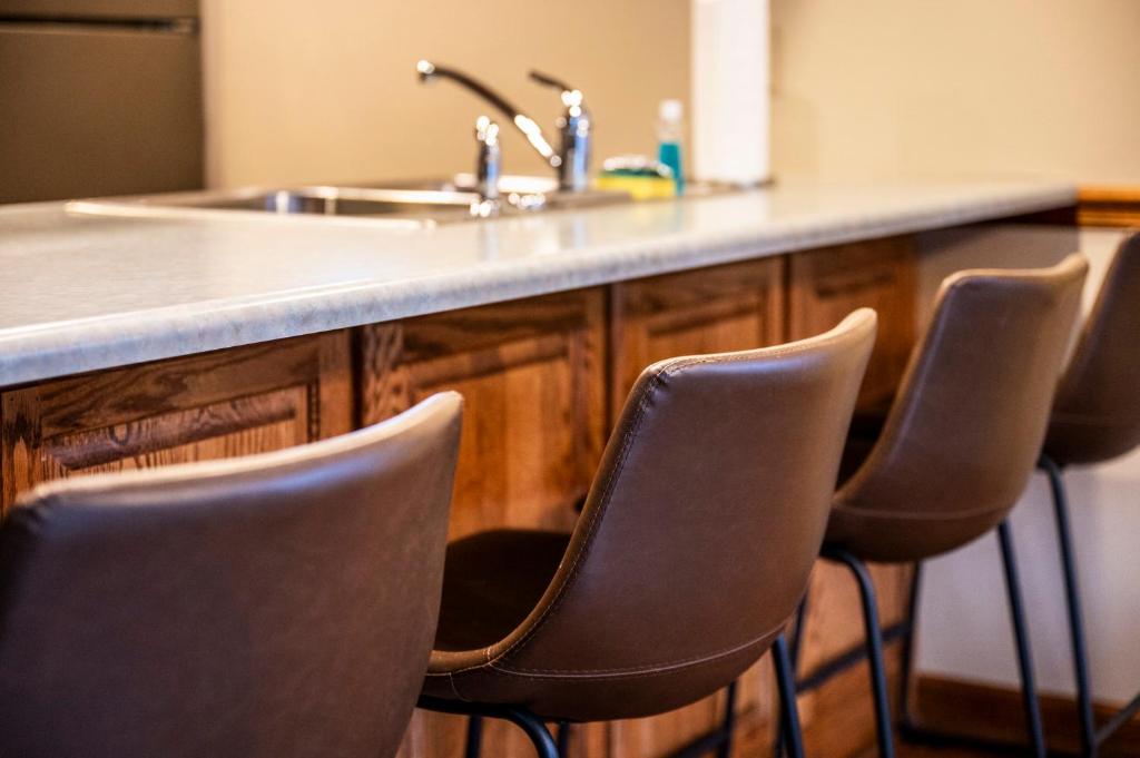a kitchen counter with a sink and four chairs at Lazy Dayz by Avada Properties in Pigeon Forge