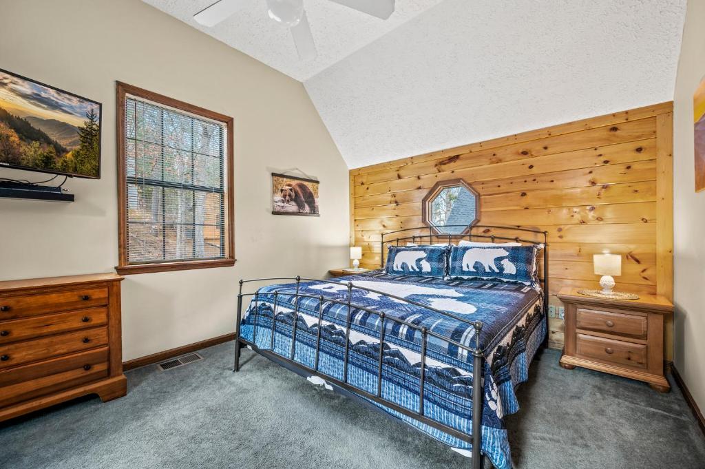 a bedroom with a bed and a wooden wall at Lazy Dayz by Avada Properties in Pigeon Forge