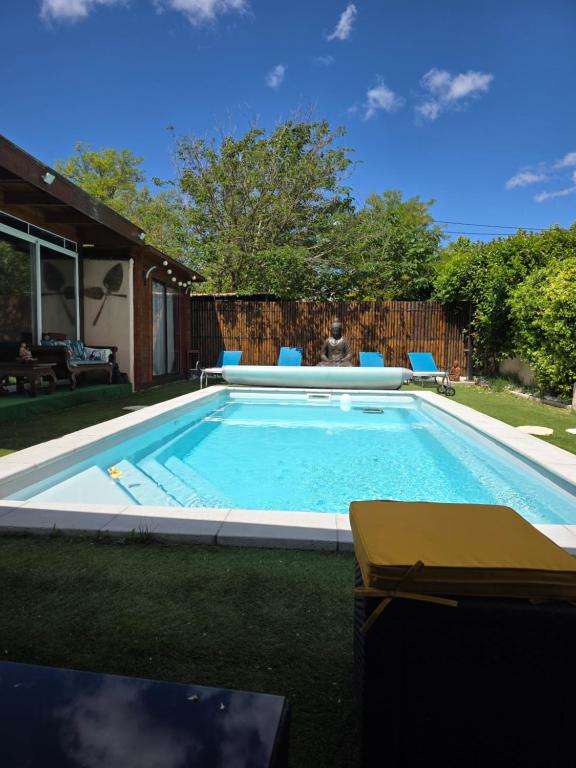 a swimming pool in a yard with blue chairs at Le Garlaban in Aubagne