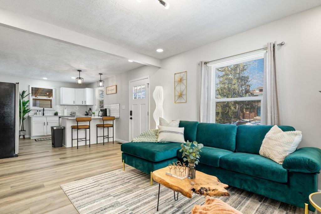 een woonkamer met een groene bank en een keuken bij Game Room Retreat with Firepit and Gym, Sleeps 12 in Indianapolis