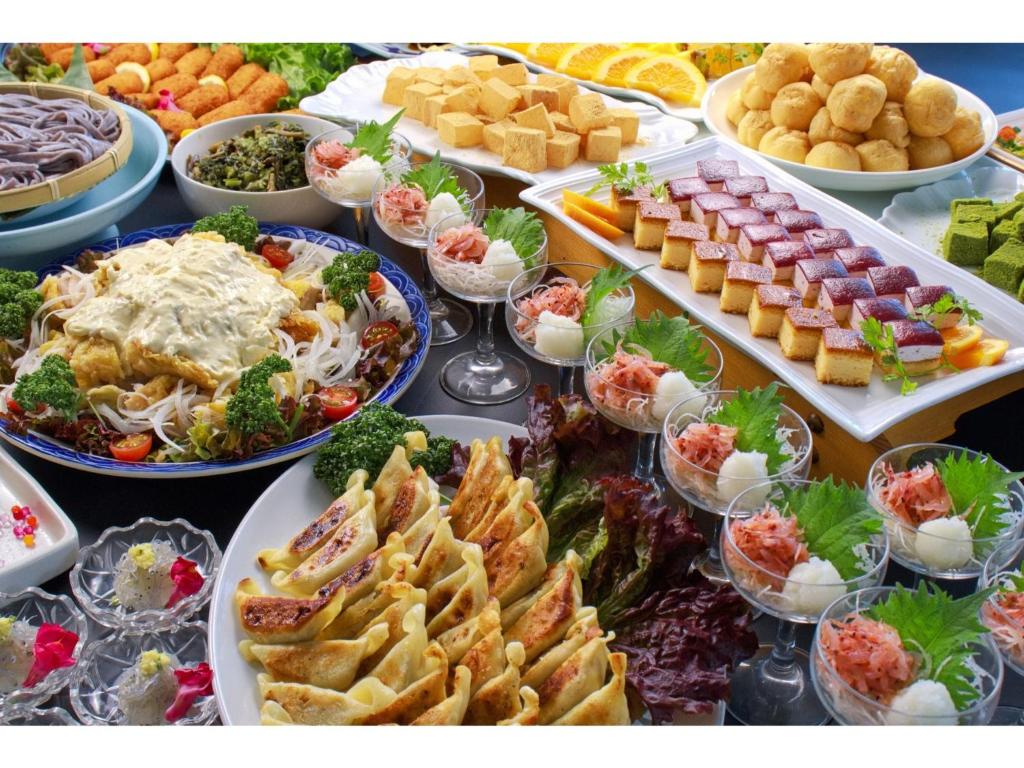 a buffet filled with different types of food on plates at Dogashima Onsen Hotel - Vacation STAY 55276v in Tago