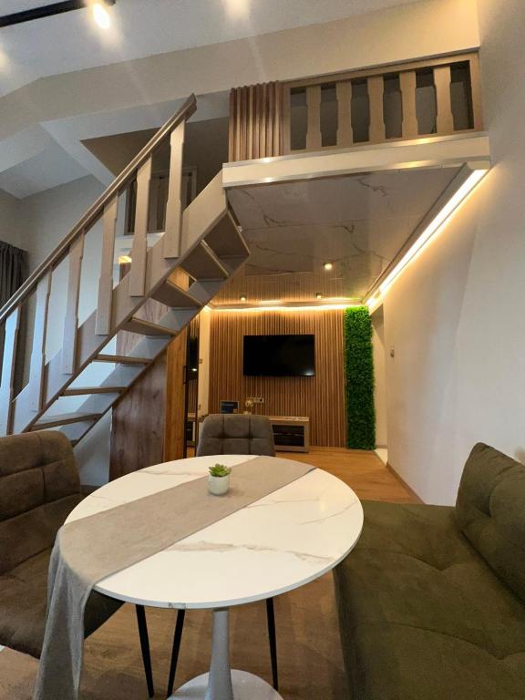 a living room with a table and a staircase at First Line Apartment 2 in Balchik