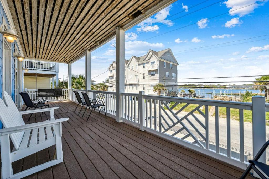 porche con sillas y vistas al agua en Sandy Paws PF with ICWW and SEA Views and a POOL, en Carolina Beach