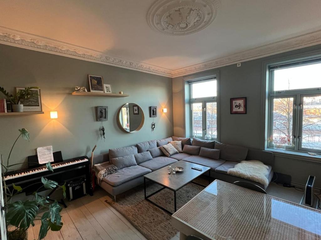 a living room with a couch and a piano at Staymate 15 minutes from Barcode in Oslo