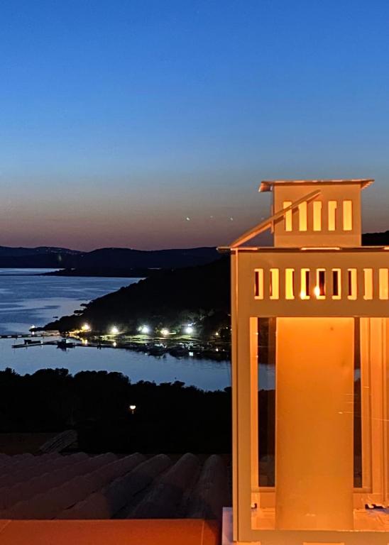 a building with a view of the ocean at night at Sea Cottage overlooking Seagull Island in Porto Rafael