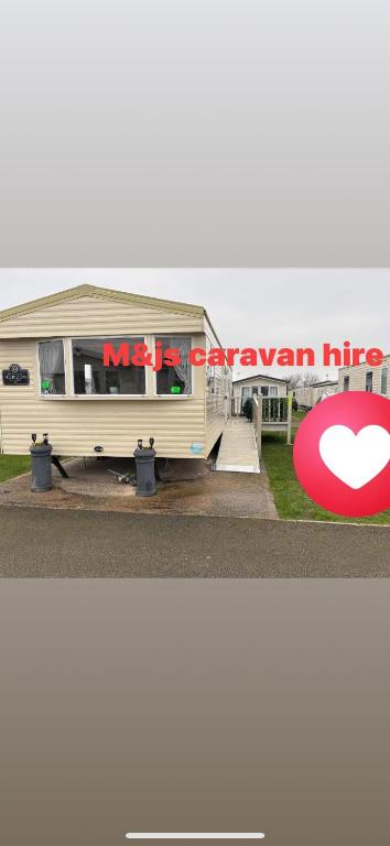 a white trailer with a red sign on it at M&js caravan hire in Kinmel Bay