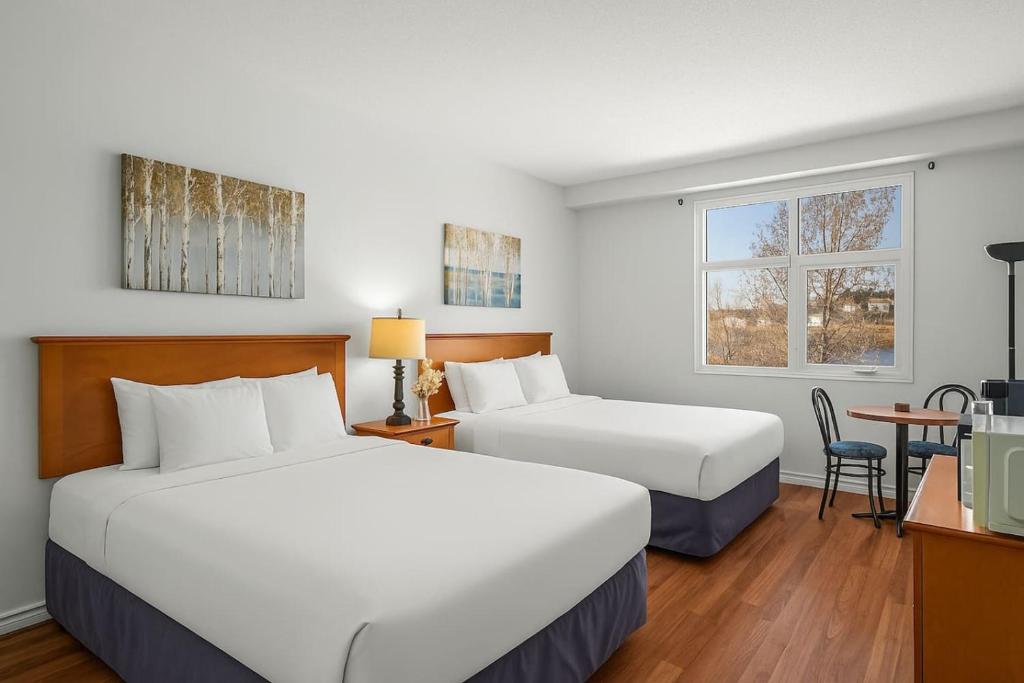 a hotel room with two beds and a table at Comfy Rockies Retreat for 4 Canmore DT Near Banff in Canmore