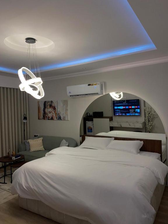 a bedroom with a large white bed and a blue light at استديو دخول ذاتي konya 3 in Jeddah