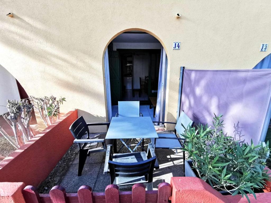 un patio avec une table et des chaises et un bâtiment dans l'établissement Résidence Les Portes De Catalogne - Studio pour 4 personnes avec loggia, Le Barcarès. Réf: 8PC_J4 MAE-8453, au Barcarès