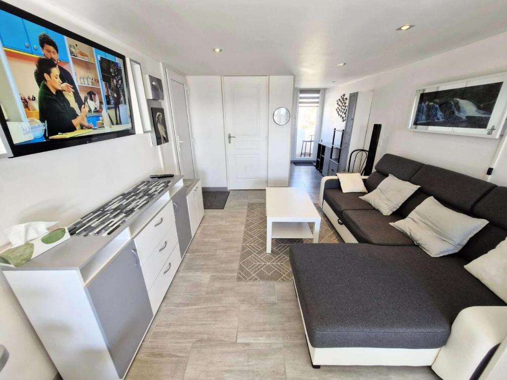 un petit salon avec un canapé et une cuisine dans l'établissement Résidence Les Arcades - 2 Pièces mezzanine 6 couchages PORT LEUCATE MAE-8483, à Leucate