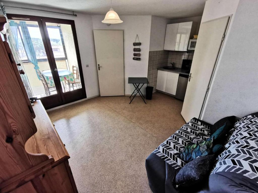 un salon avec un canapé et une cuisine dans l'établissement Résidence Le Lamparo - Appartement T2 4 couchages à Port Leucate. Réf: 4LAM_49B MAE-8503, à Leucate