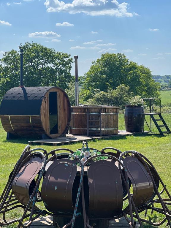 a group of barrels sitting on the grass at GreenFeilds Glamping Stargazing Yurts and Outdoor Spa in Milwich