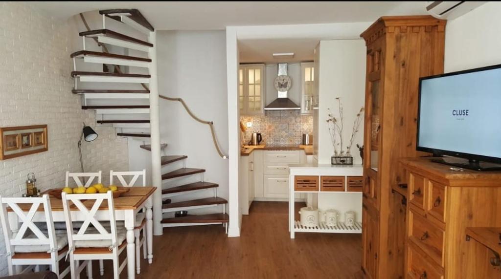 アルヴォルにあるCasa no centro Alvor- Vista Ria Alvorのキッチン、螺旋階段付きのダイニングルーム