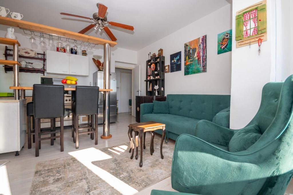 een woonkamer met een groene bank en stoelen bij Apartment Renko in Omiš
