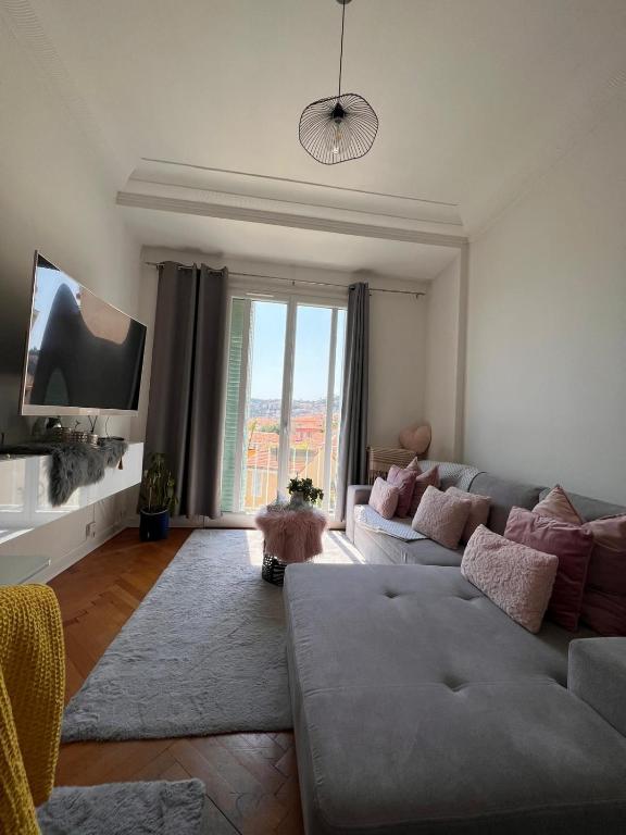 un salon avec un canapé et une télévision dans l'établissement Lovely apartment nice, à Nice