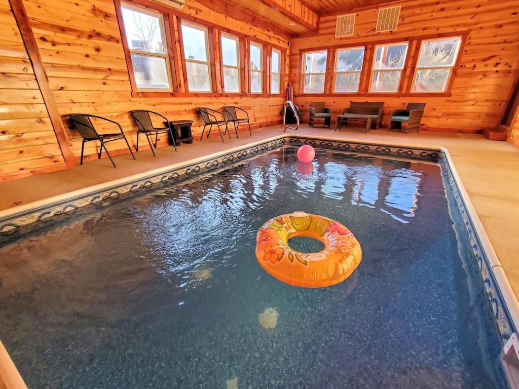 a swimming pool in a log cabin with a donut in the water at Eat, Drink and Be Beary by Avada Properties in Sevierville