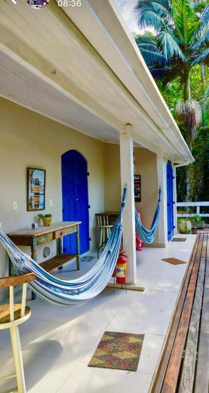 een veranda met een hangmat en een blauwe deur bij BOSQUE TOQUE TOQUE Pousada in São Sebastião