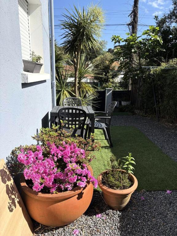 deux pots de fleurs et un banc sur une terrasse dans l'établissement Résidence Gue-81-pornichet - PORNICHET - APPARTEMENT PROCHE COMMERCES, GARE ET MER MAE-6073, à Pornichet