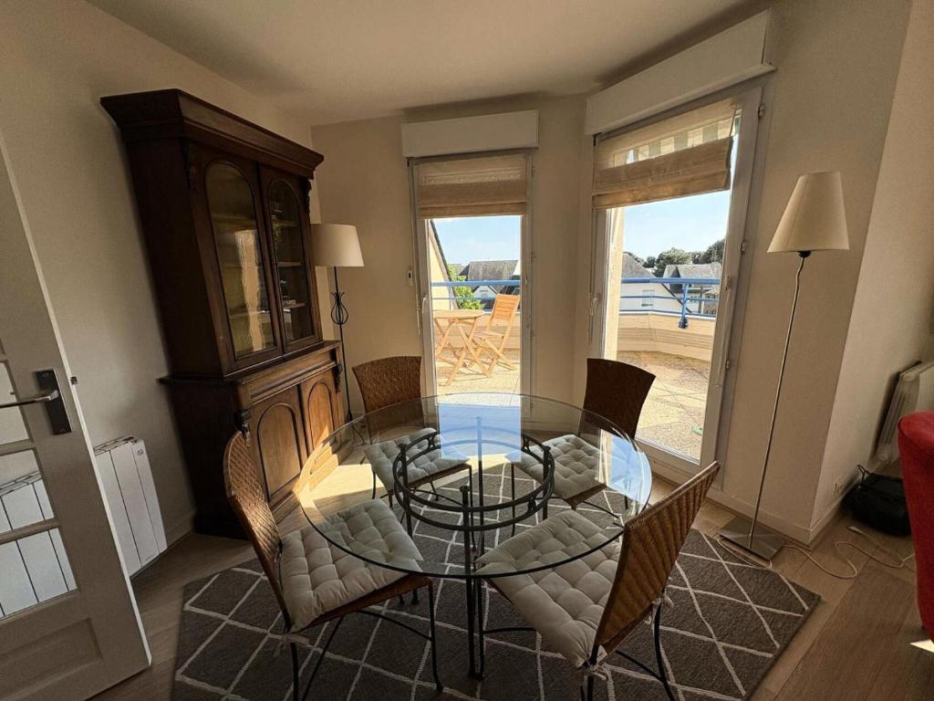 une salle à manger avec une table et des chaises en verre dans l'établissement Résidence Euros - SAINT MARC SUR MER - PROCHE COMMERCES ET PLAGE MAE-6063, à Géraud