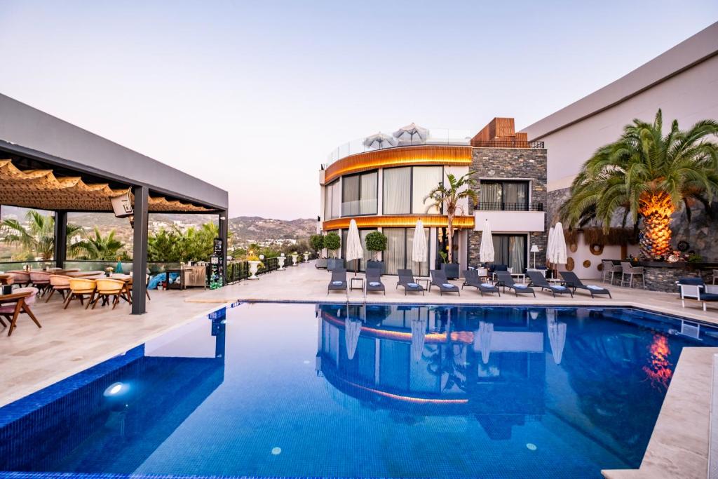 a hotel with a swimming pool in front of a building at Bombien Luxury in Bodrum City