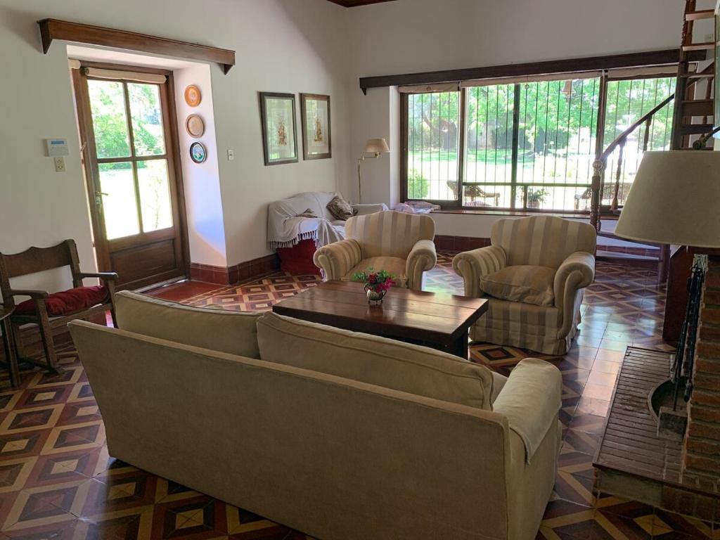 a living room with couches and a table and chairs at Villa María, nature and relaxation in Gualeguay