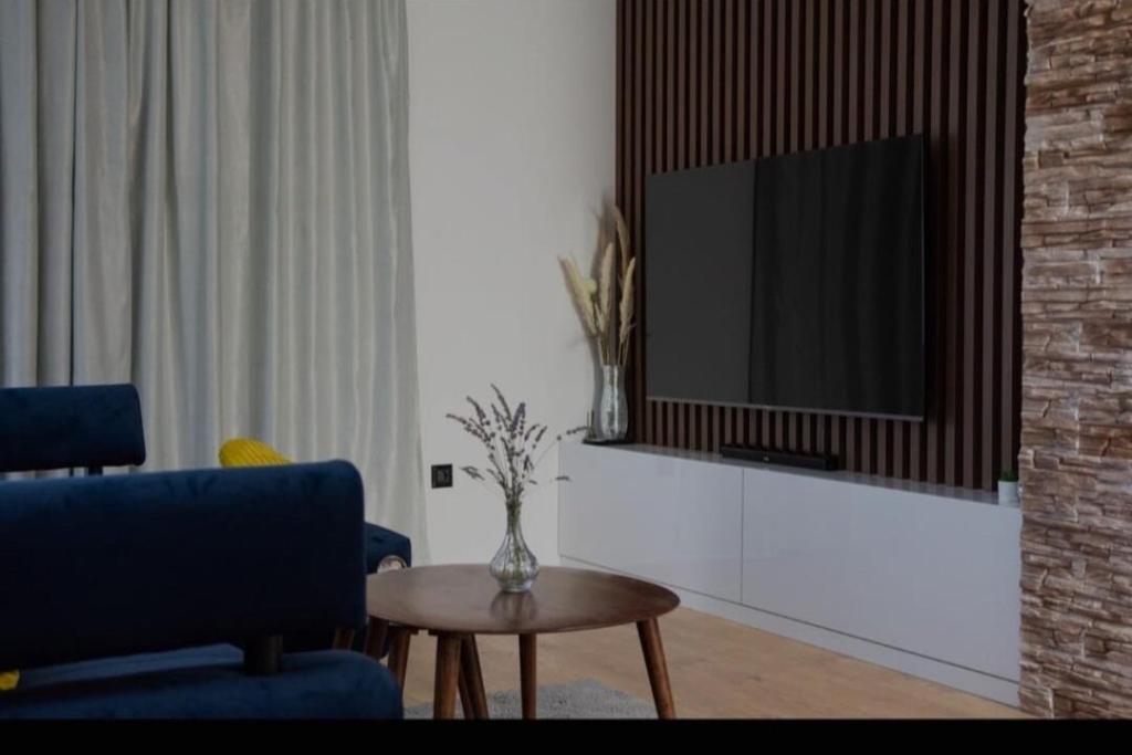 een woonkamer met een tv en een tafel bij Villa Gold in Obrovac Sinjski