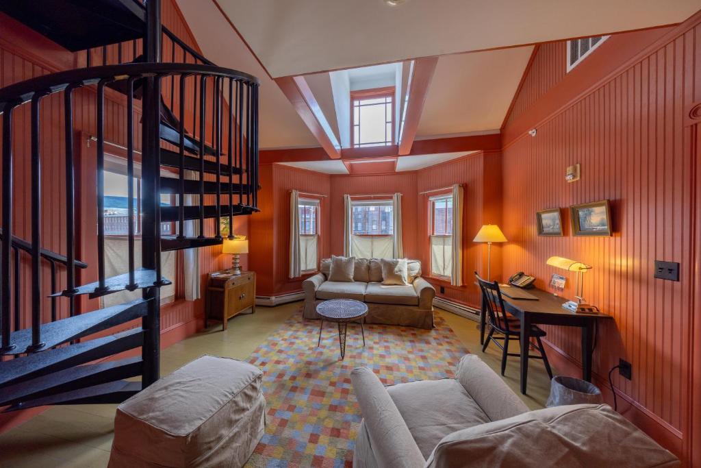 a living room with red walls and a spiral staircase at The Porches Inn at Mass MoCA in North Adams