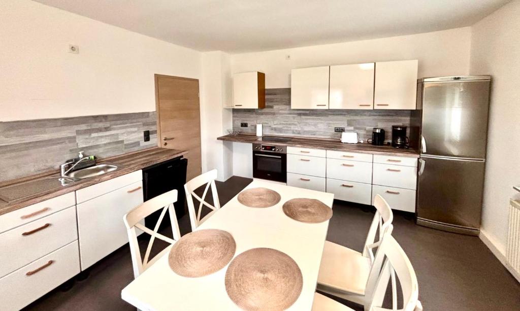 eine Küche mit Tisch und Stühlen und einem Kühlschrank in der Unterkunft Ferienwohnungen in Lohr in Lohr
