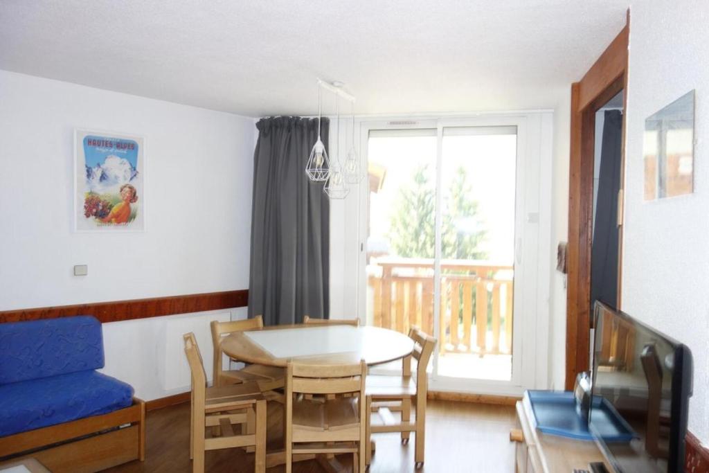 un salon avec une table et un canapé bleu dans l'établissement Résidence Christiania - APPARTEMENT ALPE D'HUEZ QUARTIER BERGERS MAE-2571, à Huez