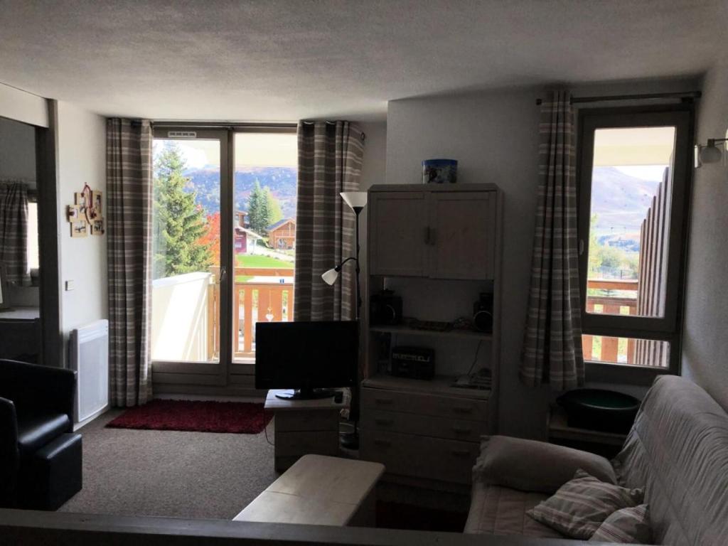 un salon avec un canapé et une grande fenêtre dans l'établissement Résidence Christiania - APPARTEMENT ALPE D'HUEZ QUARTIER BERGERS MAE-2871, à Huez