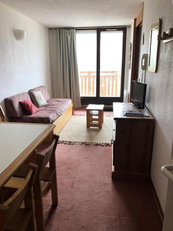 - un salon avec un canapé et un bureau avec un ordinateur dans l'établissement Résidence Christiania - APPARTEMENT ALPE D'HUEZ QUARTIER DES BERGERS MAE-3041, à Huez