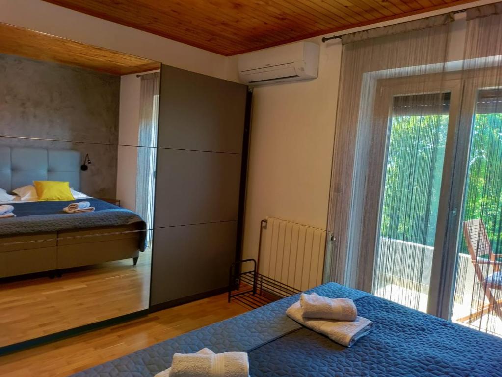 Un dormitorio con una cama y un espejo grande. en Apartment Bulić, en Bičići