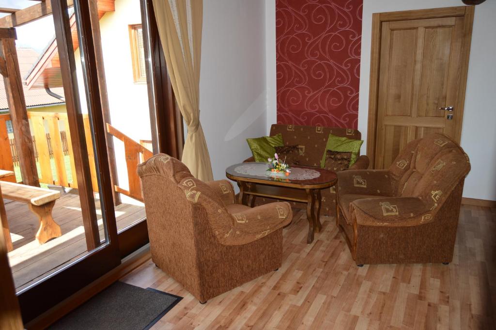 uma sala de estar com duas cadeiras e uma mesa em Drevený Raj Apartmán em Hrabušice