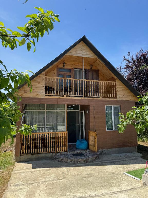 a house with a porch and a balcony at Green Field Cottage,Chakvi in Batumi