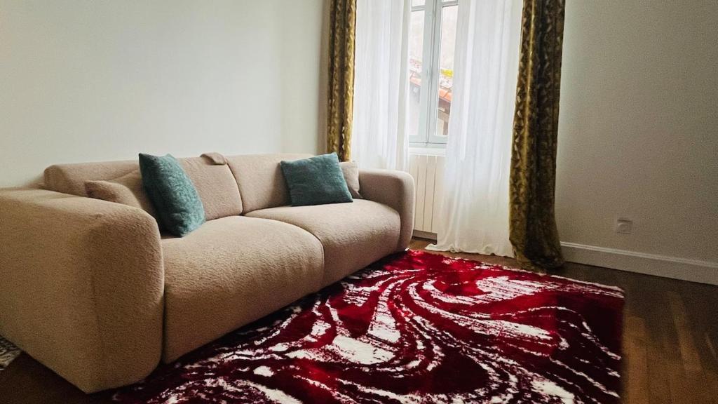 a living room with a couch and a red rug at Appartement Quartier Jardin Public in Parthenay