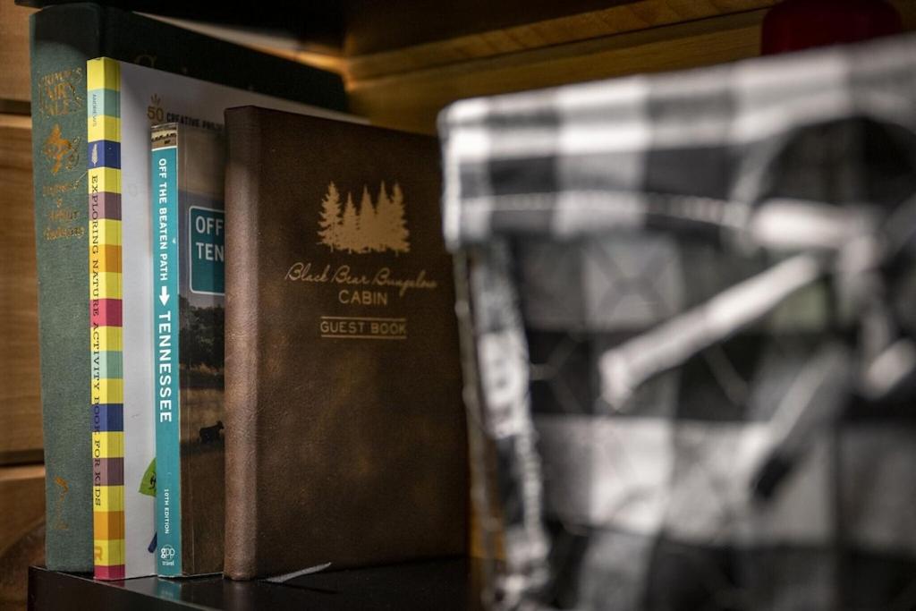 dos libros están sentados en un estante de libros en Black Bear Bungalow by Avada Properties, en Gatlinburg